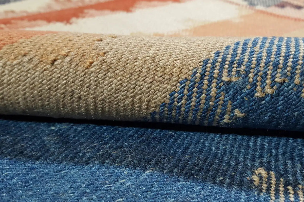 Close-up of the carpet fabric with a blue section and beige details along the edge.