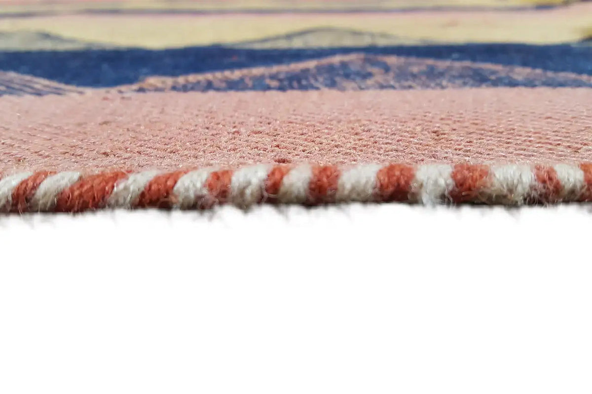 Close-up of a rug edge with short fringes and multicolored stripes, blue-yellow-terracotta