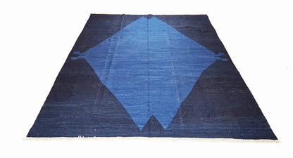 Rectangular rug with a dark blue background and a large blue diamond pattern