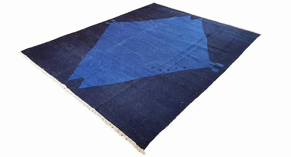 Square rug with a blue diamond pattern, dark blue border, and fringes