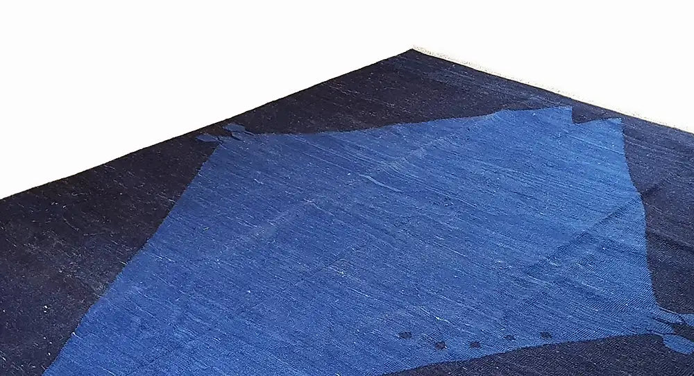 Oblique view of a rug with a large blue diamond pattern and dark triangles