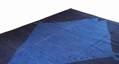 Oblique view of a rug with a large blue diamond pattern and dark triangles