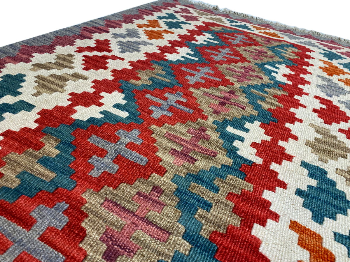 Close-up: kilim rug with cross and diamond patterns in many colors, textured