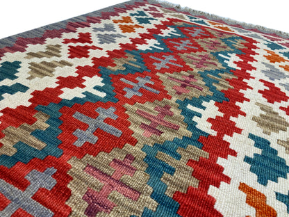 Close-up: kilim rug with cross and diamond patterns in many colors, textured