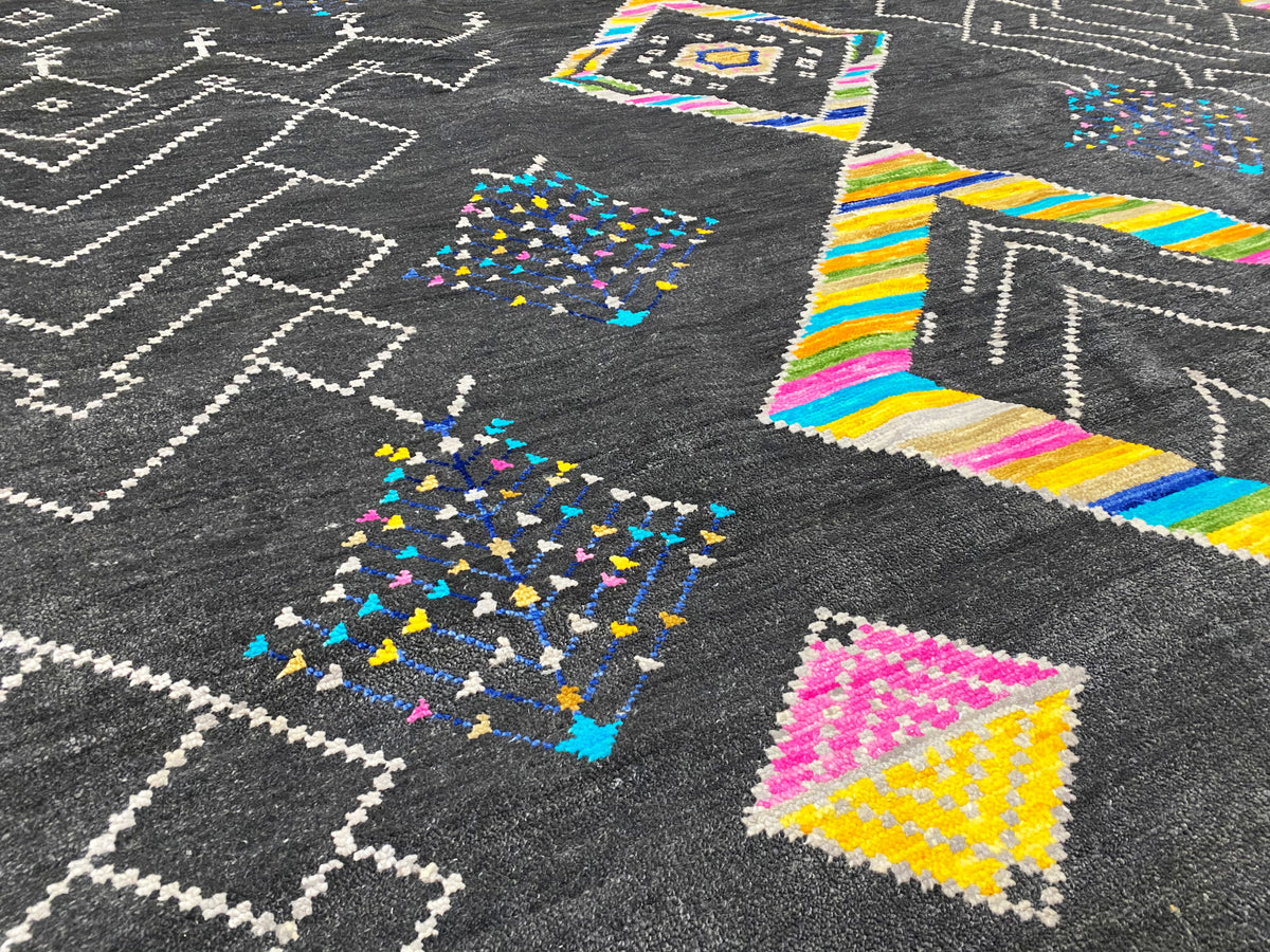 Close-up: black rug with white zigzag lines and colorful diamond patterns