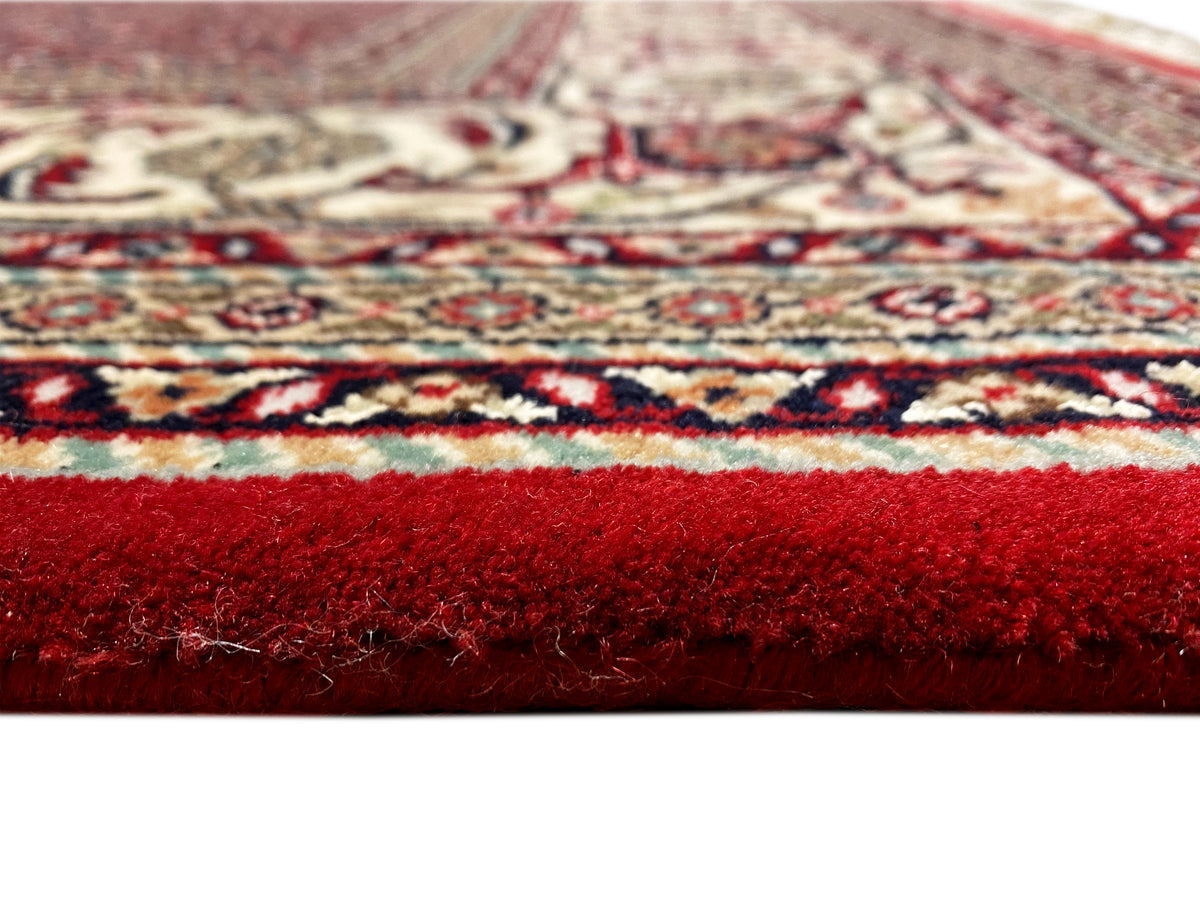 Bidjar carpet with a deep red ground, ornamental medallion, and cream-colored borders