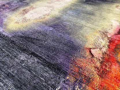 Designer rug with an abstract pattern in purple, blue, cream, and orange; high-pile texture.