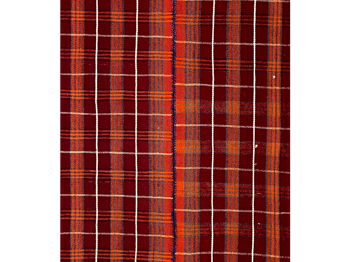 Close-up of a carpet surface: red checkered grid with fine beige lines and small color accents