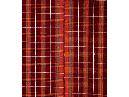 Close-up of a carpet surface: red checkered grid with fine beige lines and small color accents