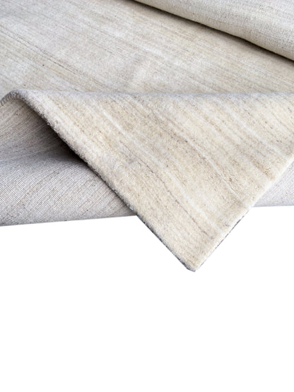 Natural gabbeh rug, folded, fine striped texture and selvedges