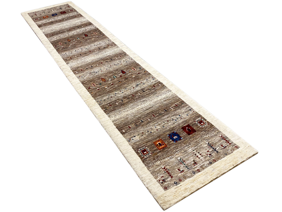 Gabbeh runner rug lengthwise from an oblique perspective: gray-brown stripes, colorful ornaments