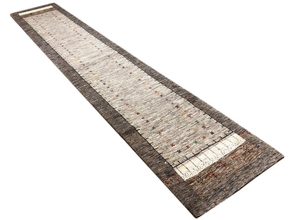Gabbeh runner rug with a light beige pile, dark brown border, and colorful patterned dots