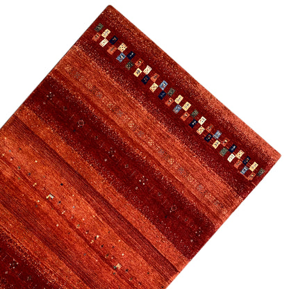 Gabbeh rug with reddish-brown stripes and a decorative multicolored border pattern