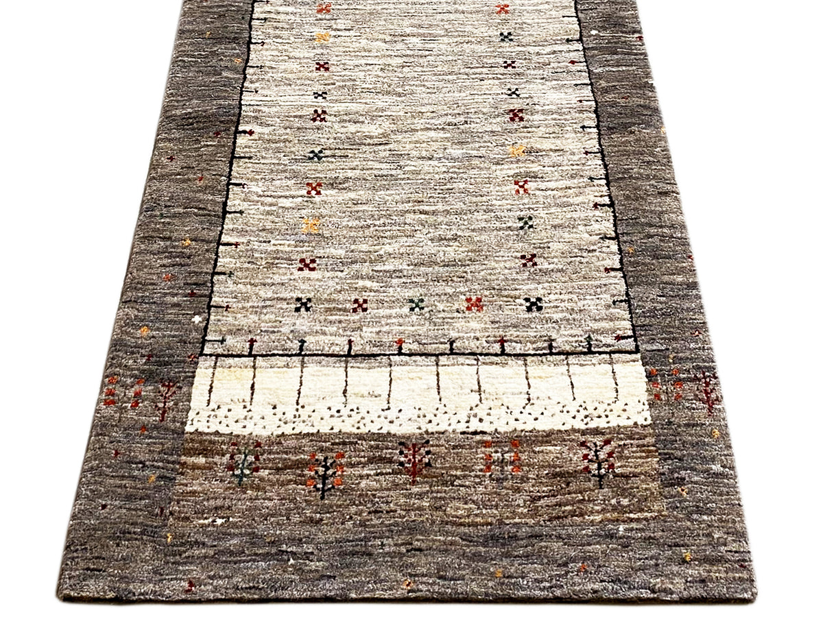 Gabbeh runner rug, broad central motif on a light pile with a dark gray border
