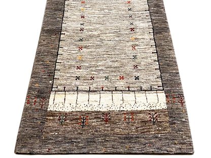 Gabbeh runner rug, broad central motif on a light pile with a dark gray border