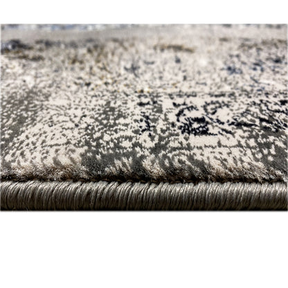 Carpet edge with fringe and dense pile; gray-brown surface with blue shading in the pattern