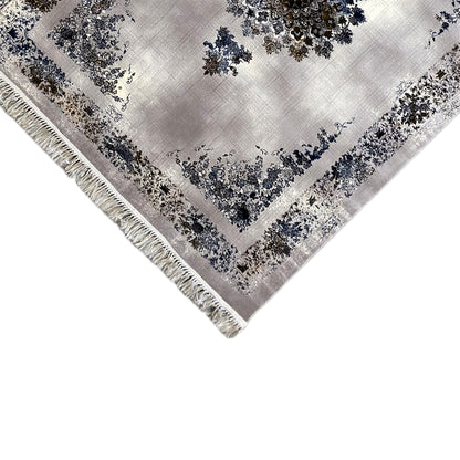 Corner view of a medallion rug with border, blue-and-gold motifs, and fringes
