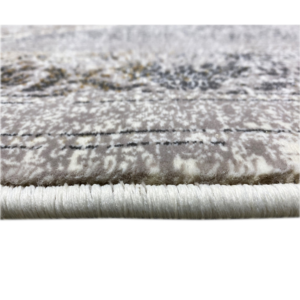 Close-up of carpet edge: fringe and pattern line, silver-gray