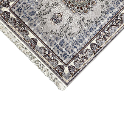 Corner of a Nain rug: blue-gray ornamental pattern with a bordered edge and long fringe