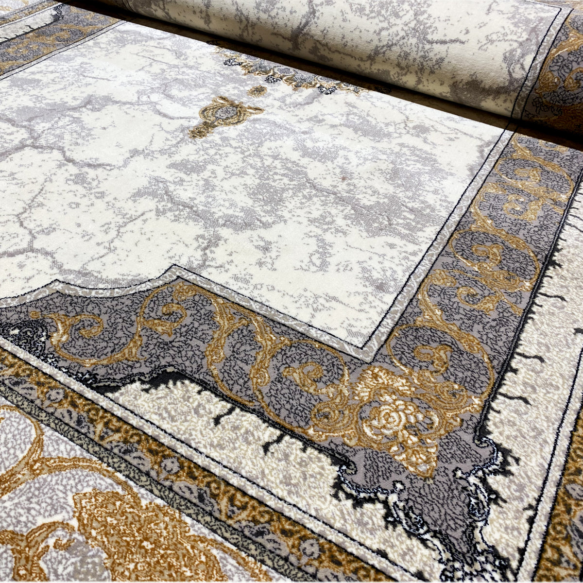 Rolled-up section of carpet with border and fringes, light cream-colored background