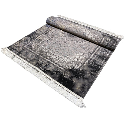 Vintage gray rug with a bordered frame, muted sheen, and fringes