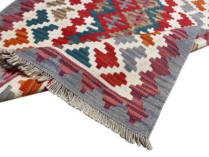 Kilim rug with an all-over geometric pattern and fringes along the edge, multicolored