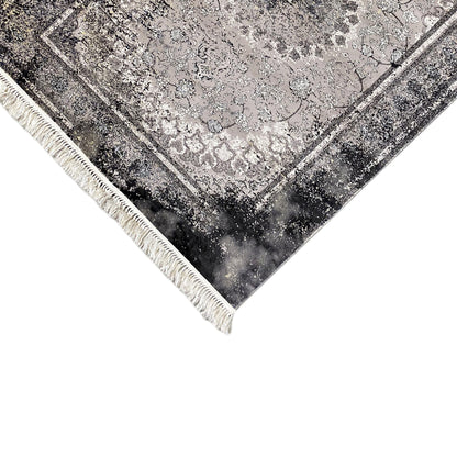 Corner of a vintage rug: gray ornamental pattern, decorative border, and fringe