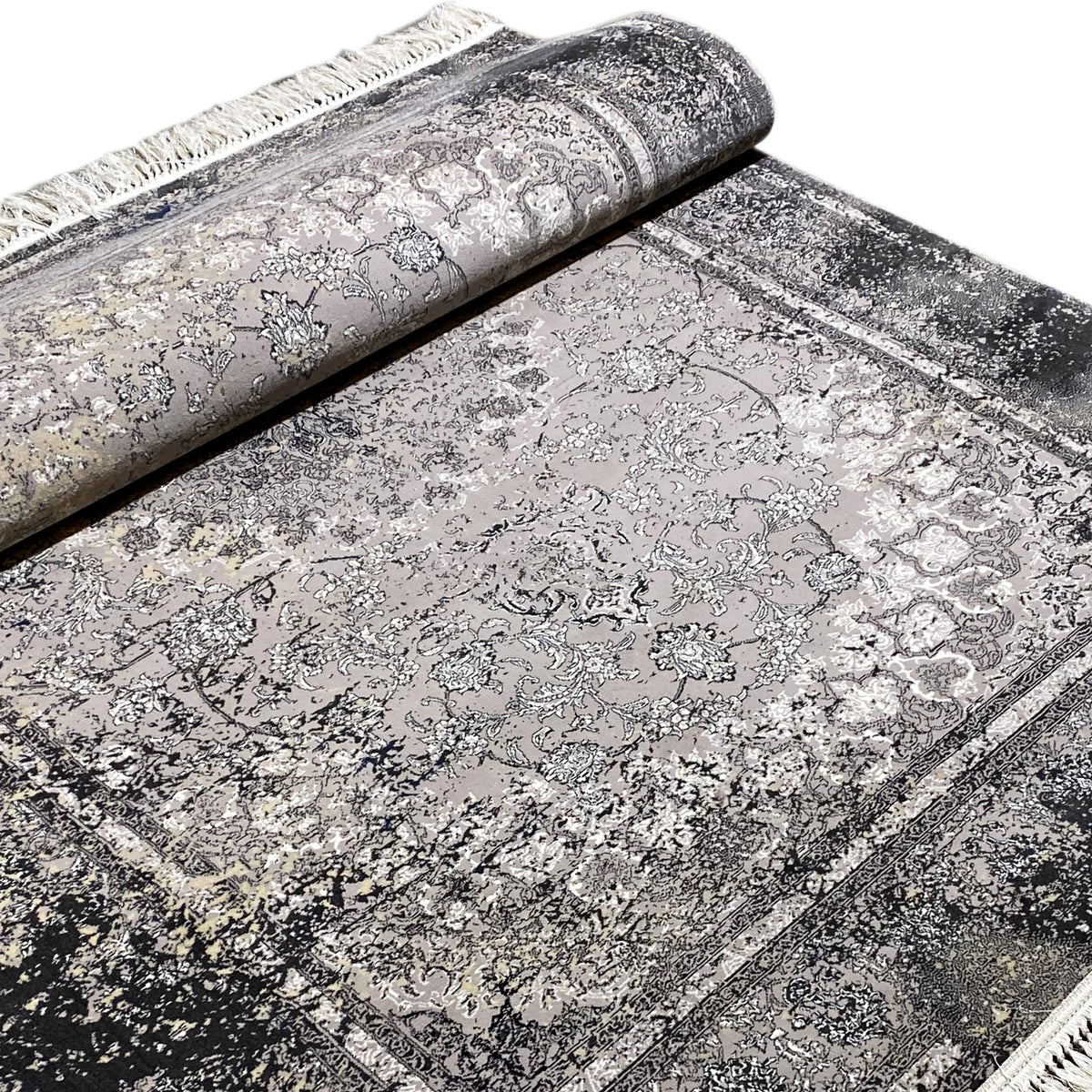 Vintage rug in gray, partially rolled, with a detailed ornamental pattern