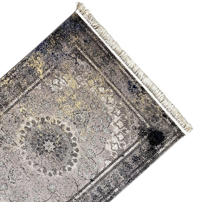 Vintage rug in gray, shown at a diagonal angle with a border and white fringe