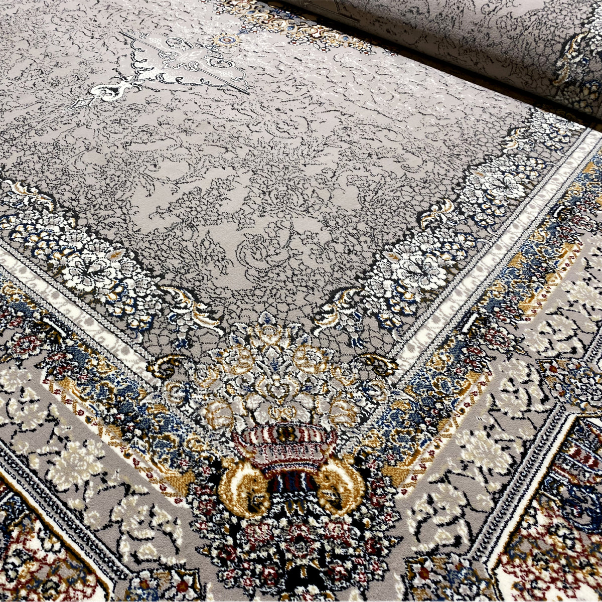 Close-up view of the Noah rug: textured patterns, floral motifs in blue and gold