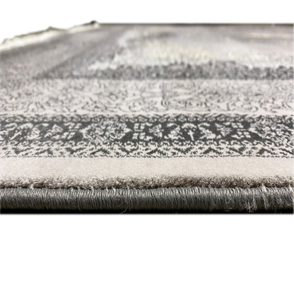 Close-up of the border and pile: fringed edge on the gray carpet