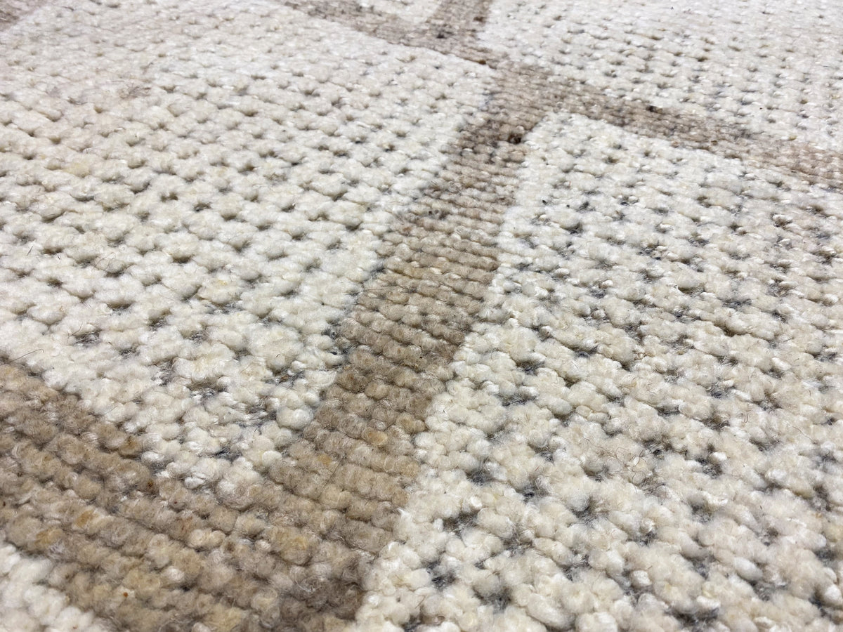 Berber rug close-up: dense pile with beige and gray color blocks