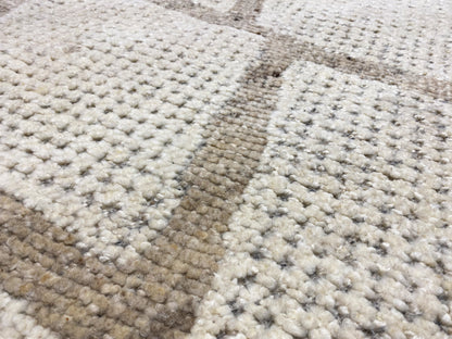 Berber rug close-up: dense pile with beige and gray color blocks