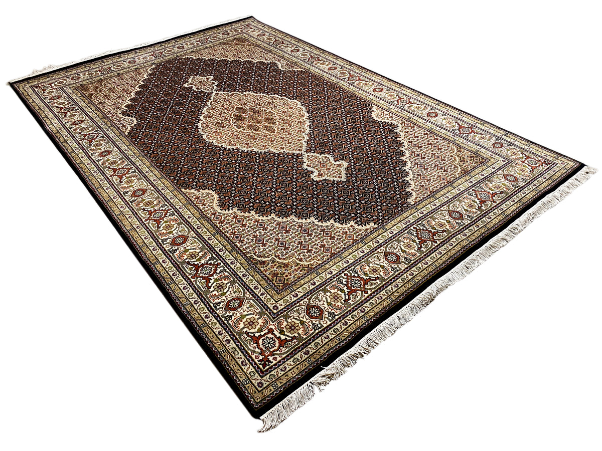 Brown Indo-Tabriz rug spread out with a central motif and patterned border