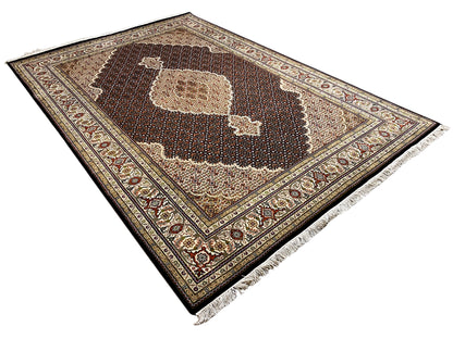 Brown Indo-Tabriz rug spread out with a central motif and patterned border