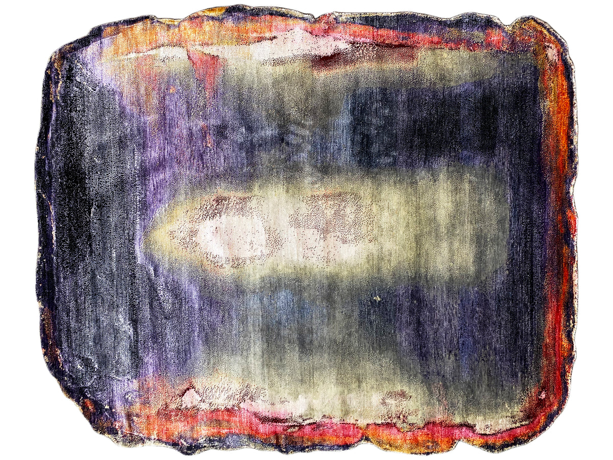 Designer rug with irregular, bound edges and a color gradient in purple, blue, and orange.