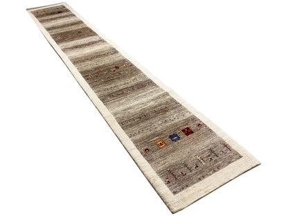 Gabbeh runner rug at an angle: dark stripes, light border, and multicolored squares.