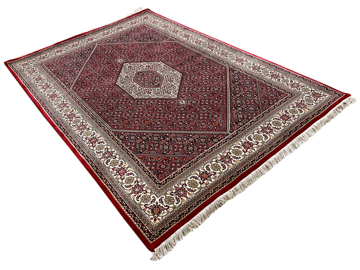 Red carpet with a central medallion, geometric ornament, and cream-colored border