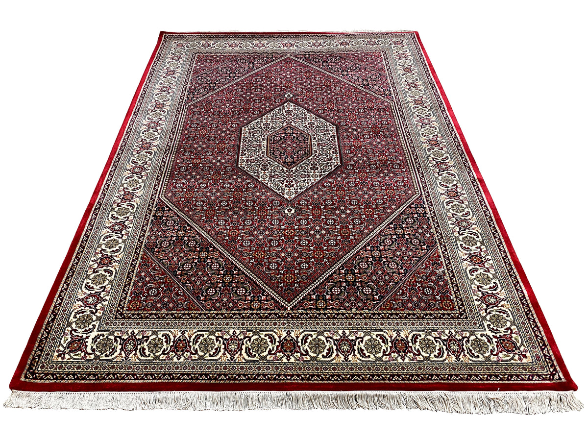 Red carpet with a central octagonal medallion, decorative border, and white fringe