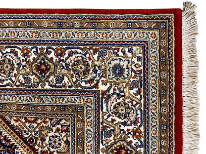 Carpet with a red base, white and blue ornaments, and a fringe border along the sides