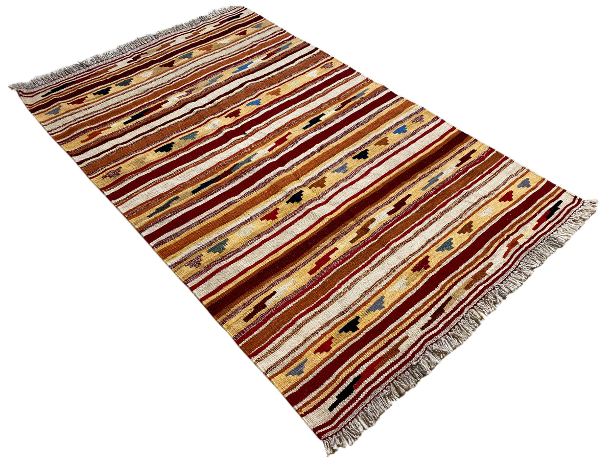 Kilim rug with a striped pattern in shades of red, beige, and blue, with fringes