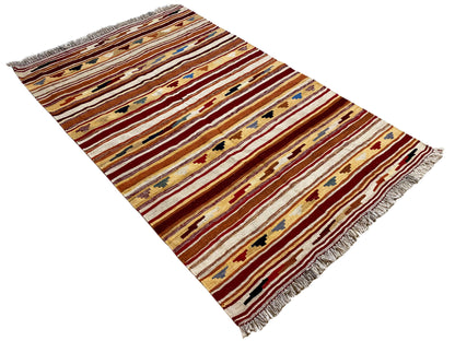 Kilim rug with a striped pattern in shades of red, beige, and blue, with fringes