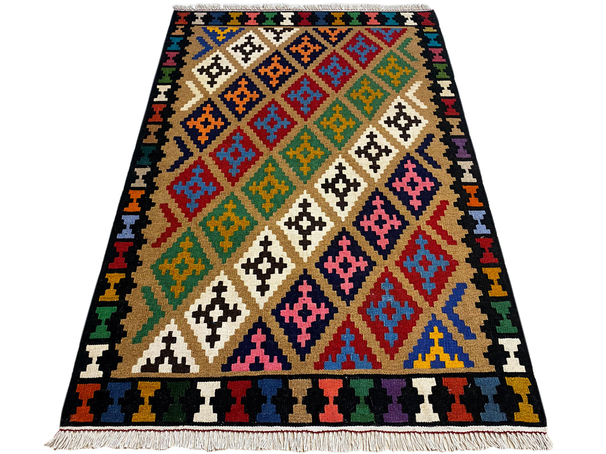 Kilim rug with a geometric patchwork pattern, colorful on a dark background, rectangular.