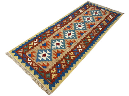 Kilim rug with beige sections and geometric patterns in blue, brown, and white