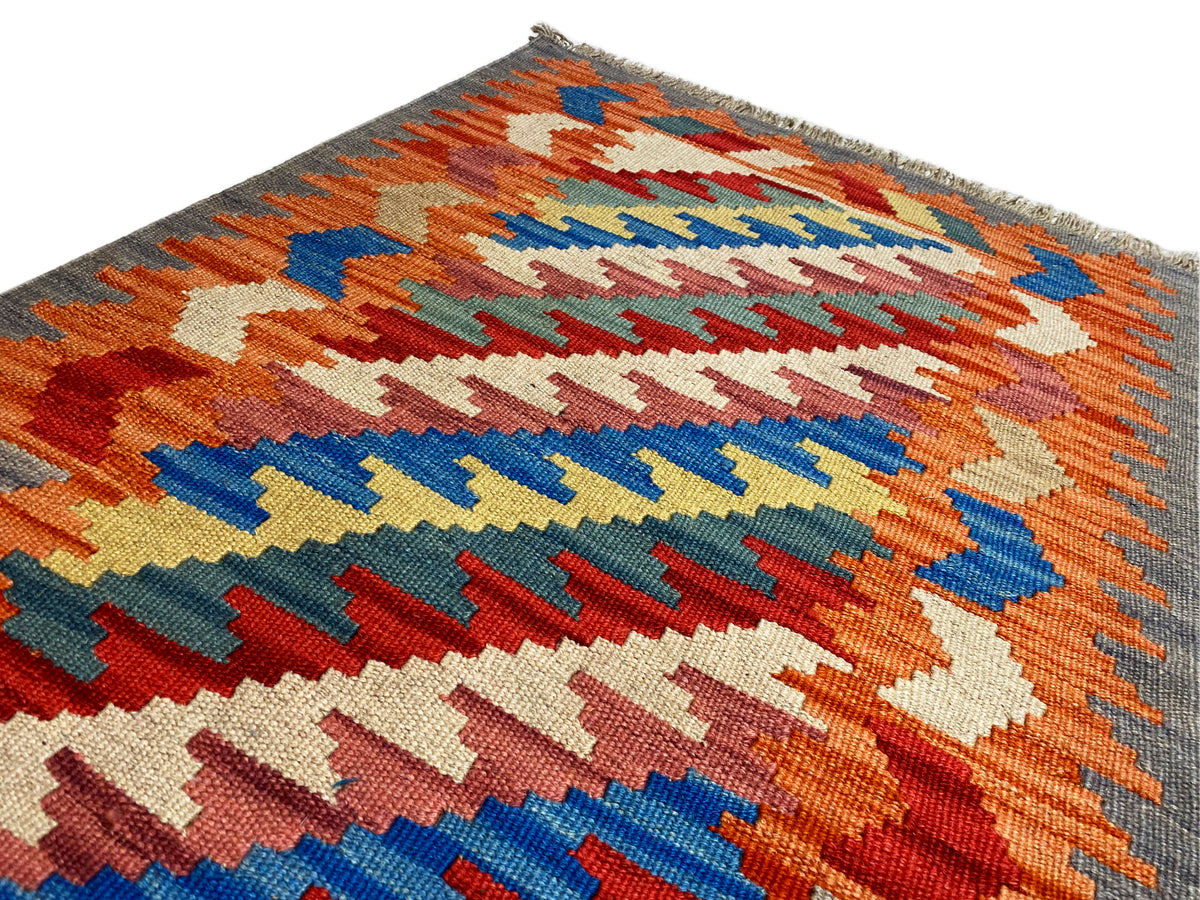 Kelim Qashqai rug, orange zigzag pattern with colorful accents and fringes, 121x78 cm