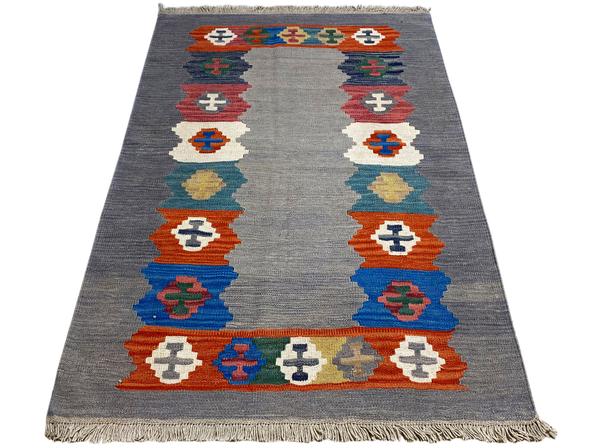 Gray heathered kilim rug with a rectangular border pattern and fringes
