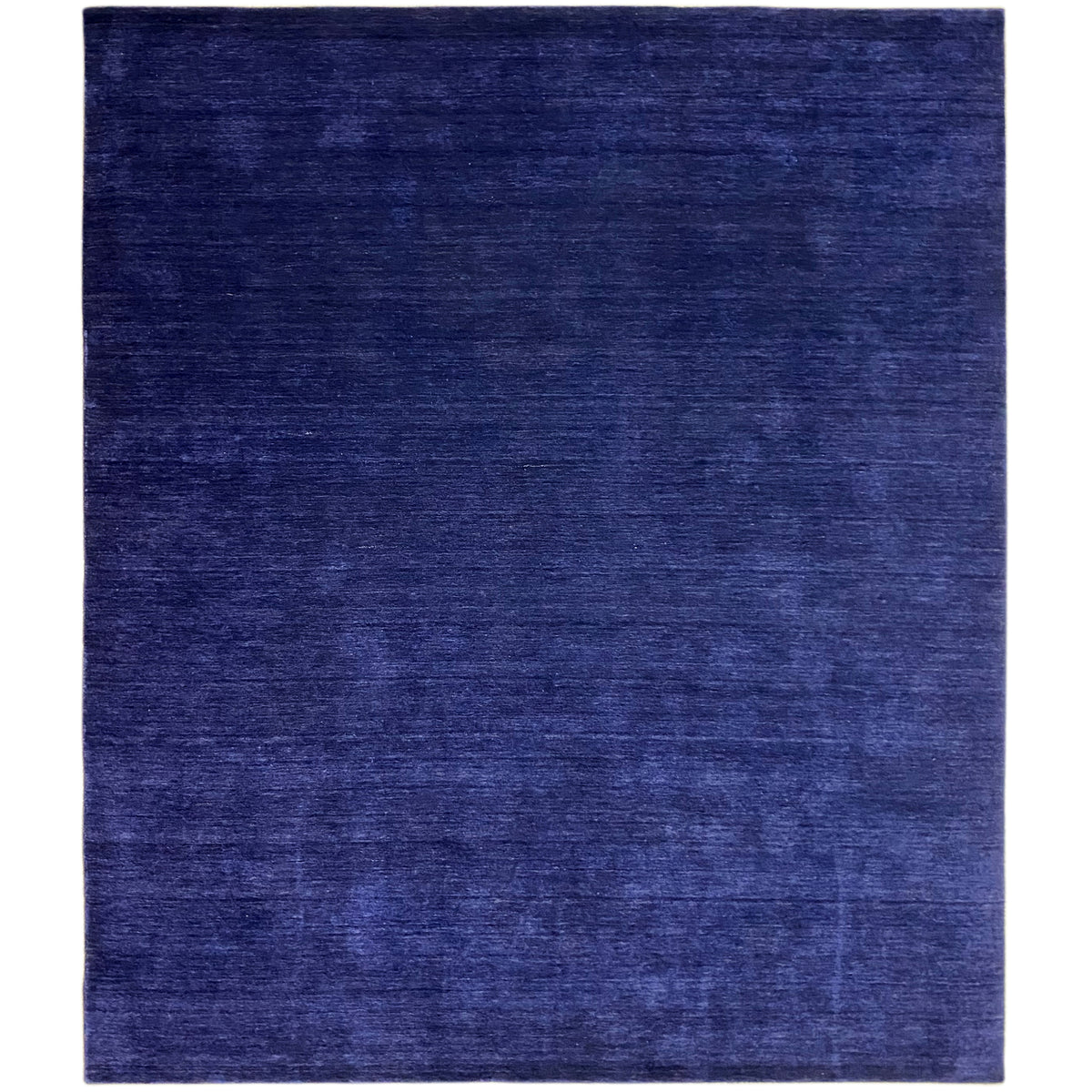 Blue rectangular rug with a matte surface and fine, subtle pattern.