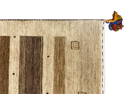 Gabbeh rug with a beige field, dark stripes and small ornaments, knotted fringe