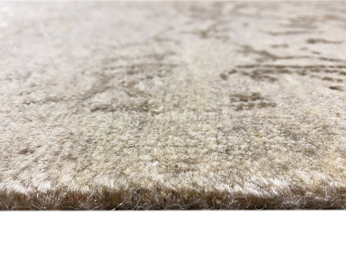 Designer rug with a soft, light beige pile and a dense, vintage-colored texture