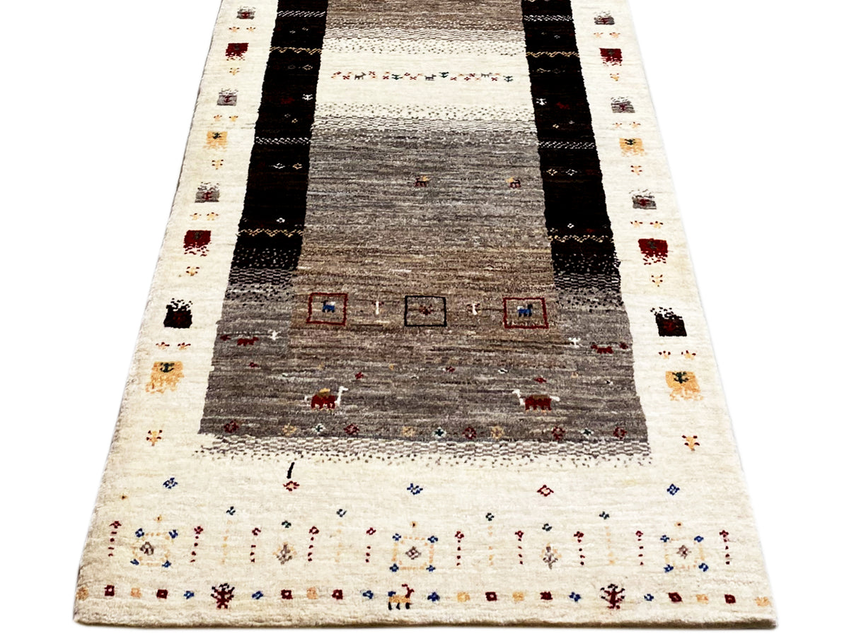 Gabbeh runner with a deep central field, surrounding stripes, and colorful small motifs